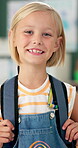 Student, girl and smile with backpack in classroom for education, back to school or ready for knowledge. Scholar, portrait or happy face at preschool with confidence for learning, studying or excited