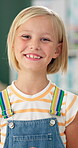 Student, girl and face or happy in classroom for education, back to school or ready for knowledge. Scholar, portrait and excited at preschool with confidence or pride for learning, studying or lesson