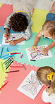 Children, group and drawing in class at kindergarten with paper, learning and diversity on floor. Kids, friends and above for sketching butterfly, color pen and creativity for education at academy