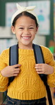 Student, girl and happy with backpack in classroom for education, back to school and ready for knowledge. Scholar, portrait or excited face at preschool with confidence for learning, study and lesson