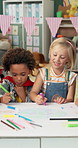 Boy, girl and drawing with paper at kindergarten with group in class, learning and happy with diversity. Children, friends and smile with talk, color pen and together for education for development