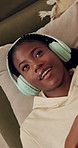 Headphones, music and above of black woman on sofa listening to audio, song and radio in home. Entertainment, streaming subscription and person relax with earphones for album playlist in living room