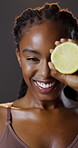 Lemon, vitamin c and portrait of black woman with skincare for natural beauty, benefits and cosmetics in studio. Dermatology, fruit and girl with facial care, smile or healthy skin on dark background