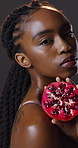 Skincare, face or black woman in studio for pomegranate wellness, cosmetics or treatment on dark background. Calm, portrait or girl with fruit for collagen, sunscreen or antioxidant beauty benefits