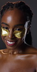 Skincare, face or black woman with eye mask in studio wellness, anti aging or collagen facial on dark background. Gold, beauty or patch portrait for reverse, restore or cosmetic barrier protection