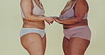 Body positivity, studio underwear and women holding hands for shape, size and weight acceptance, inclusion and solidarity. Empowerment, lingerie fashion and closeup curvy friends on green background