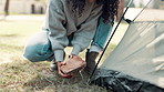 Camping, rock and woman with tent setup for shelter for holiday, vacation and adventure outdoors. Travel, campsite and person with stone for pegs in forest, nature and woods to relax in countryside