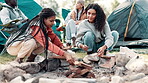 Camping, friends and firewood in nature for heat by tent on adventure, holiday or vacation in forest. Diversity, travel and women with sticks for campfire, backpacking or winter getaway in woods