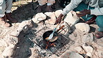 Camping, hand and cooking with pot on fire for fish breakfast, hungry or nutrition meal in nature. Travel, campsite and person with utensil for fishing trip, weekend break or adventure in forest