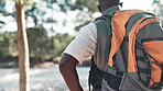 Black man, back and hiking with nature, trees and blue sky with breathe and break. African athlete, sport and exercise for health, wellness and workout on adventure trail for travel and survival