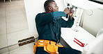 Black man, plumbing and pipe with repair for fix, leak or sink in maintenance or service at home. Young African, male person or plumber working on faucet, basin or water leakage in kitchen at house