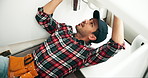 Man, plumbing and pipe with wrench for repair, maintenance or leak on sink, fix or service at home. Young male person, handyman or plumber tools on faucet, basin or water leakage in bathroom at house