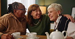 Embrace, happy and senior woman in lounge of nursing home for communication. Smile, discussion and group hug of elderly friends in retirement talking, bonding and relaxing in living room at house