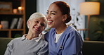 Senior woman, caregiver and hug in home for care, support and love on sofa in living room. Elderly person, nurse and face in house on couch for companion with smile, happiness and wellness together