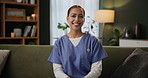 Smile, caregiver and face of woman on sofa for healthcare, medical support or trust in living room. Wellness, portrait and nurse in scrubs for confidence, happiness or volunteer work in nursing home