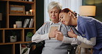 Senior, woman and nurse with photo for support with grief, memory and mourning in home with hugging lost love. Elderly, person or caregiver with picture frame in wheelchair for remember or compassion