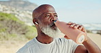 Senior black man, drinking water and outdoor for running on road with earphones for music, training or fitness. African person, bottle and hydration on street for detox, workout or audio subscription