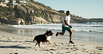 Fitness, running and man with dog by beach for race, workout or marathon training with health. Sports, pet and mature African male athlete by tropical ocean or sea for cardio exercise with puppy.