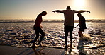 Beach, sunset and senior friends playing in waves on holiday, vacation and adventure together. Silhouette, summer and people laugh and splash by ocean for bonding, retirement and fun outdoors