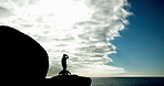 Mountain, silhouette and person with dog in nature with blue sky and clouds for hiking exercise. Trekking, outdoor and shadow of athlete with pet, puppy or animal on cliff for fitness workout.