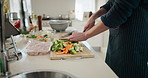 Hands, chopping and cooking in home, kitchen and preparation for food or nutrition with diet. Person, vegetables and carrots for lunch, dinner or meal with cutting board and ingredients for stir fry