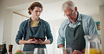 Tablet, cooking and elderly man with son in kitchen for online recipe, instructions and teamwork. Apron, nutrition and family with connection for ingredients, steps and preparing dinner in home