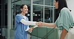 Doctor, nurse and handshake for teamwork with paperwork in hospital for healthcare as professional in ER. Female people, talking and collaboration in meeting or debrief in clinic with medical record