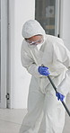 Man, hazmat suit and sweep for cleaning, pandemic and disinfection for virus safety, biohazard for policy. Person, bottle and lockdown for illness spread in office, sanitation and protection service