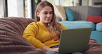 Relax, bean bag and woman in home with laptop, typing and reading on website for freelance career. Research, networking and girl in living room with remote work, writing and computer for online job