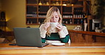 Woman, laptop and drinking coffee at cafe as freelancer for remote work, enjoy and relax. Female person, restaurant and tea with aroma for fresh or warm beverage as journalist or blogger for website