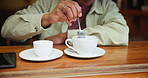 Hand, stirring and coffee on table in cafe, restaurant and bistro to enjoy hot beverage. Counter, expresso and cappuccino of male customer with caffeine, breakfast and sugar in tea cup in morning