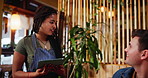 Restaurant, customer and waitress with tablet for order, display menu and typing info. Small business, female employee and digital application for hospitality service, helping or talking with client
