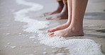 Closeup, beach and people with water, legs and summer with vacation, adventure and carefree. Feet, wet and outdoor with ocean, foam and journey with nature, travel and splash with sand and Hawaii