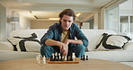 Man, chess and game in home on sofa with strategy, solution or problem solving in contest in living room. Elderly person, toys and board with idea for king, queen and knight with challenge in lounge