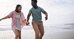 Beach, joy and interracial couple for romance, honeymoon and travel for fun, happy and walking. Woman, holding hands or sea on date to show partner adventure, happiness or bonding or play on holiday