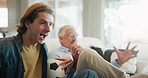 Father, son and celebration watching tv on sofa for support, sports and happy bonding together in home. Winning, dad and excited adult child on couch with football, soccer ball and cheers on weekend