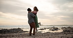 Sunset, couple hug and love at a beach with kiss, support or lifting in celebration in seaside. Sunrise, romance and bonding of people at sea excited for proposal, surprise announcement or engagement