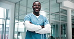 Healthcare, black man and doctor in hospital for portrait, confidence and medical care in lobby. Male nurse, success and happy in workplace for support, career and arms crossed for professionalism
