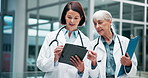 Healthcare, insurance and tablet with doctors in hospital for consulting or discussion together. Documents, medical and women mature medicine professional team of women talking in clinic for research