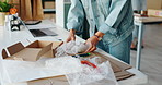 Hands, boxes and packaging for shipping at startup, warehouse and bubble wrap with safety for delivery. Person, plastic and cardboard for storage, supply chain and cargo for distribution in factory