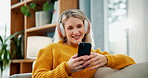Happy woman, typing and phone with headphones for communication, social media or online browsing on sofa at home. Female person in relax with headset, smile or scrolling on mobile smartphone at house