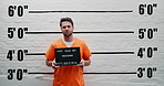 Man, criminal and suspect with sign for arrest, mugshot or violation in prison for questioning. Portrait of male person or thief with orange clothing, billboard or number for jail photo or picture