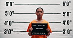 Woman, face and arrest with criminal for mugshot, violation or investigation for prison questioning. Portrait, profile or girl thief with orange clothes for board or number for jail photo or picture