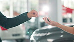 Hands, key and car dealership with salesman and customer in showroom for purchase discussion. Transport, vehicle and deal with automobile dealer handing keys to buyer after sale pitch for auto travel