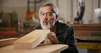 Carpenter, man and wood design in workshop for construction, manufacture and blueprint for furniture project. Male person, blow dust and woodwork production, process or creative industry for labor
