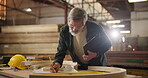 Carpenter, pencil and drawing with blueprint for construction, furniture or project. Senior person, planning and wood with tools in a creative carpentry workshop for manufacturing, art and craft