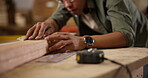 Carpenter, hands and sanding with wood beam for construction, furniture or project. Closeup of person smoothing oak with sandpaper in a creative carpentry workshop for manufacturing, art and craft