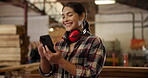 Woodwork, woman and phone with smile in workshop, headphone or safety as noise cancelling for furniture design. Smile, female carpenter and mobile for project, communication and production factory