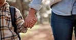 Child, mother and holding hand with walk in park for love, care or support at outdoor nature. Closeup of young mom, little boy or kid with backpack or bag for childhood, youth or safety at park