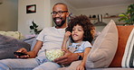 Happy dad, child and watching tv with popcorn for entertainment, bonding or movie on sofa at home. Father, kid or little boy with remote for online streaming, show or cartoon in living room at house